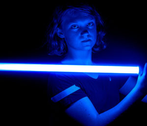 Padawan stays balanced with the light side. A blue lightsaber serves as mood lighting in a photo opp.